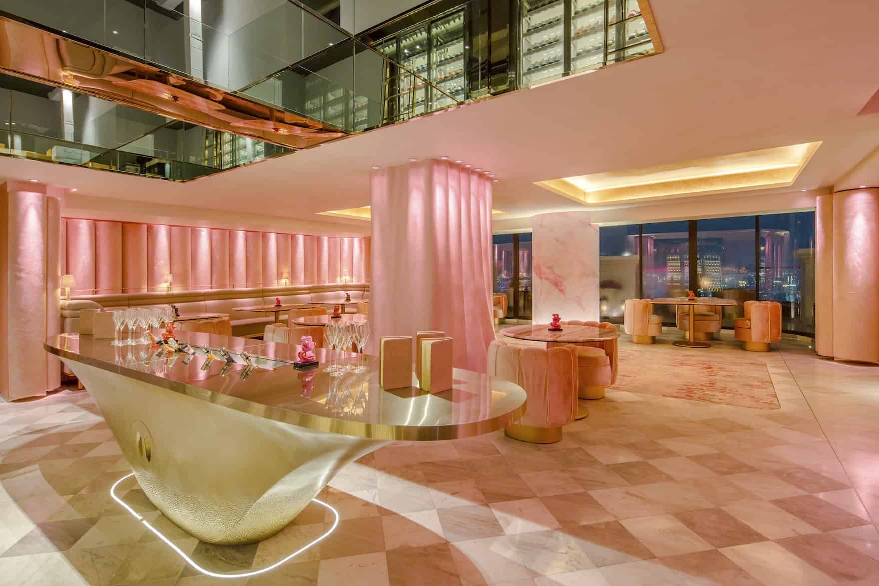 restaurant tables and bar with pink furniture and pink walls