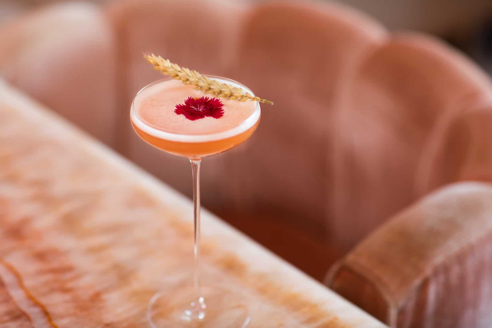 pink cocktail wheat garnish on table