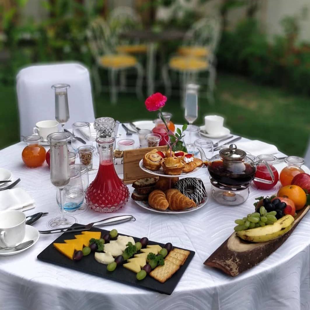A breakfast on a white table in a garden