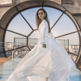 Woman wearing a white dress standing on a rooftop